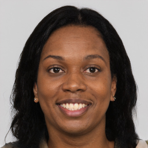 Joyful black young-adult female with long  black hair and brown eyes