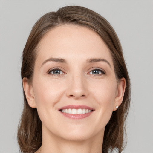 Joyful white young-adult female with medium  brown hair and grey eyes