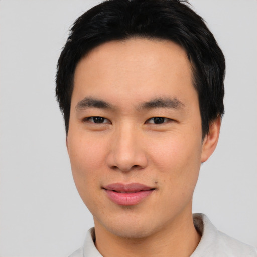 Joyful asian young-adult male with short  black hair and brown eyes