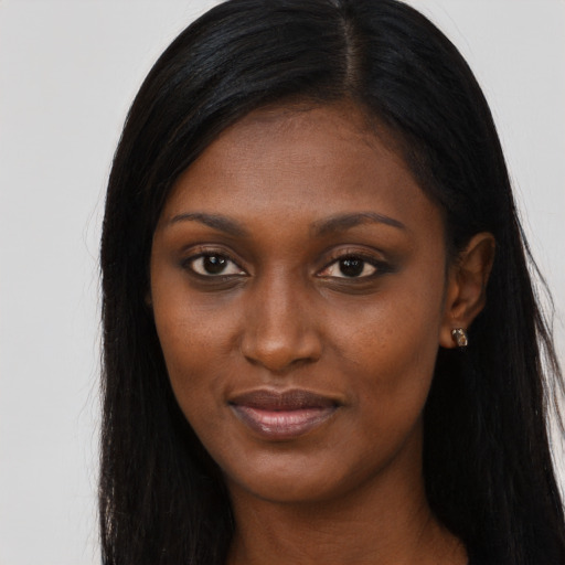 Joyful black young-adult female with long  brown hair and brown eyes