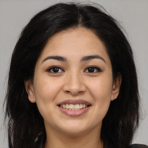 Joyful latino young-adult female with long  brown hair and brown eyes