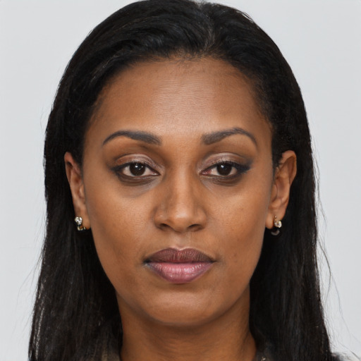 Joyful black young-adult female with long  brown hair and brown eyes