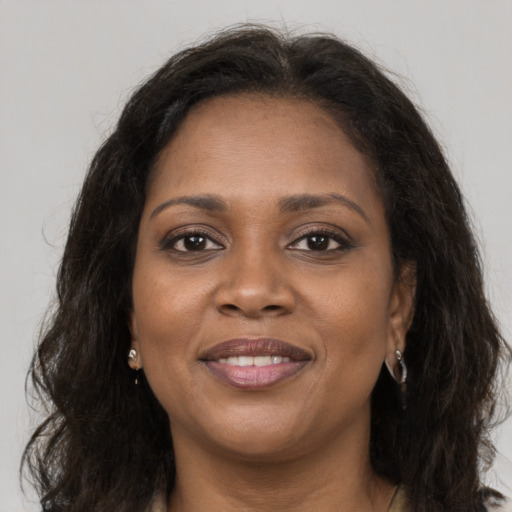 Joyful black young-adult female with long  brown hair and brown eyes