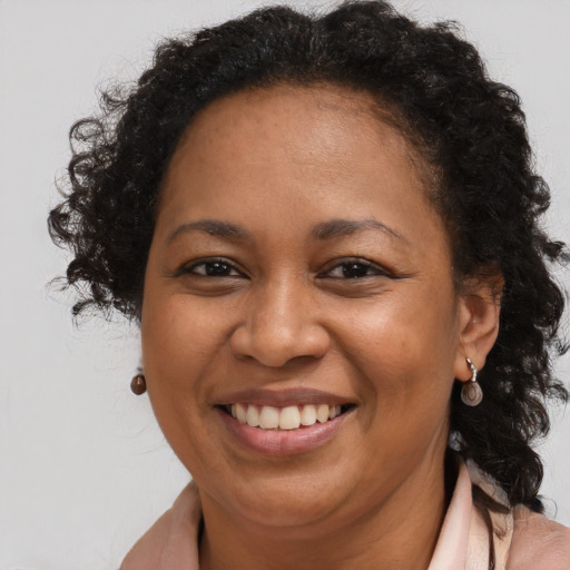 Joyful black adult female with long  brown hair and brown eyes