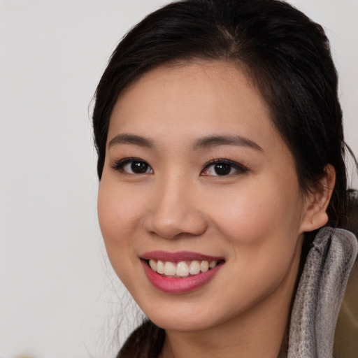 Joyful asian young-adult female with long  brown hair and brown eyes