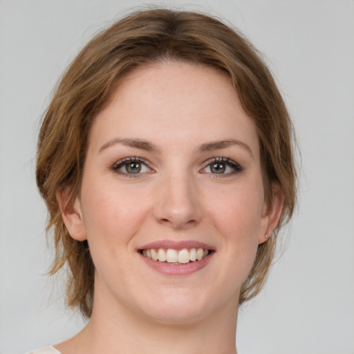 Joyful white young-adult female with medium  brown hair and green eyes