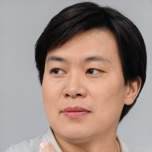 Joyful asian young-adult male with short  brown hair and brown eyes