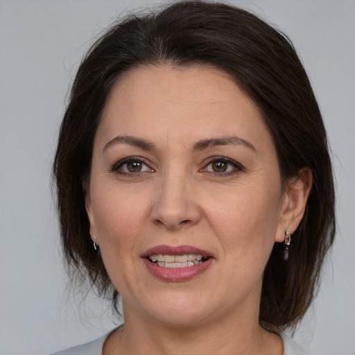 Joyful white adult female with medium  brown hair and brown eyes