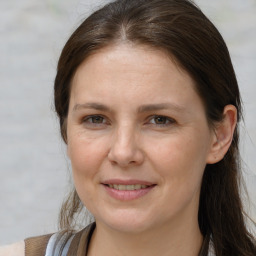 Joyful white adult female with long  brown hair and brown eyes