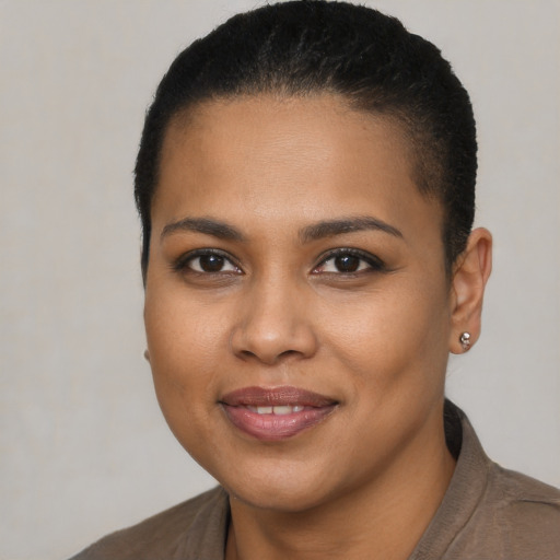 Joyful black young-adult female with short  black hair and brown eyes