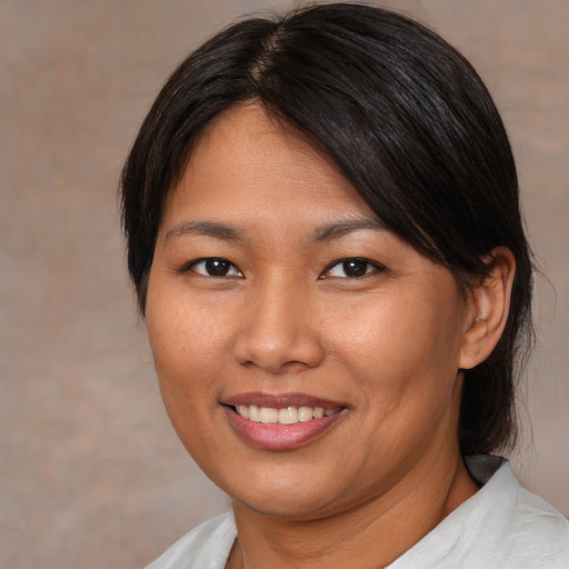 Joyful asian young-adult female with medium  brown hair and brown eyes