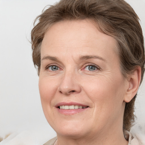 Joyful white adult female with medium  brown hair and grey eyes