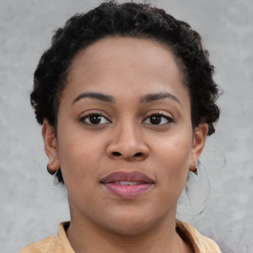 Joyful black young-adult female with short  brown hair and brown eyes