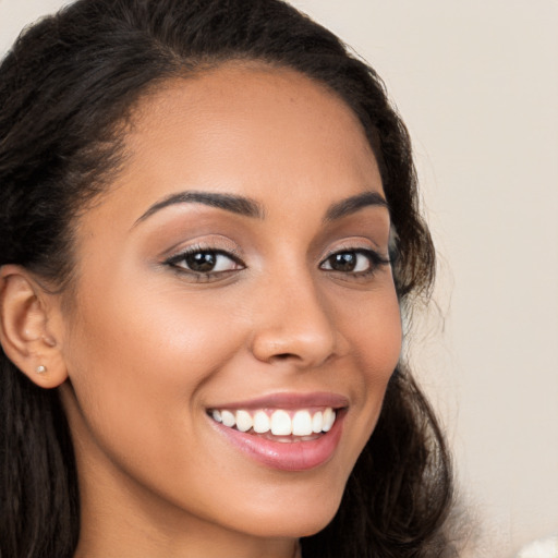 Joyful latino young-adult female with long  brown hair and brown eyes