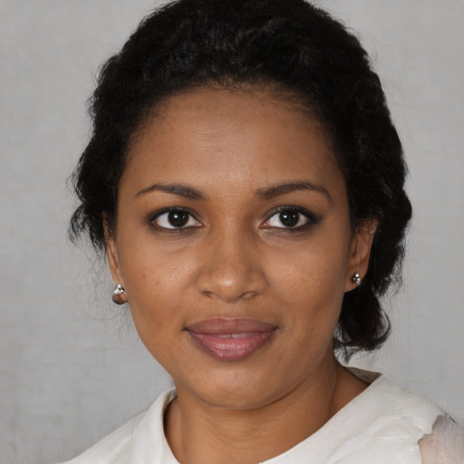 Joyful black young-adult female with short  black hair and brown eyes