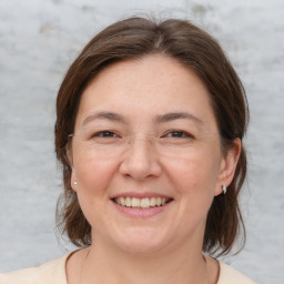 Joyful white adult female with medium  brown hair and brown eyes