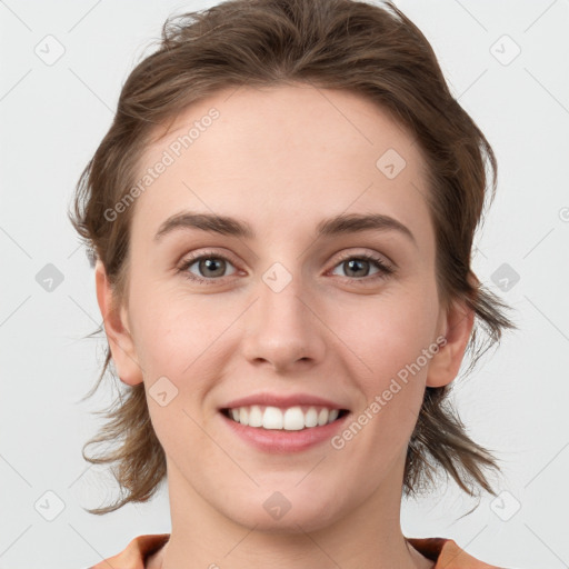 Joyful white young-adult female with medium  brown hair and grey eyes