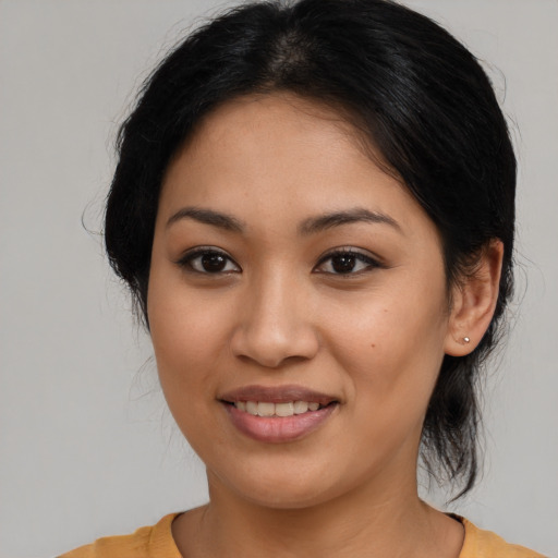 Joyful latino young-adult female with medium  brown hair and brown eyes
