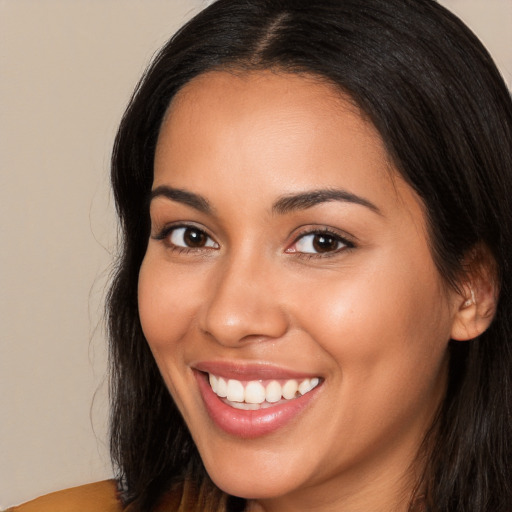 Joyful latino young-adult female with long  brown hair and brown eyes