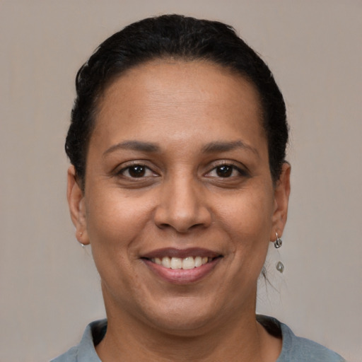 Joyful latino adult female with short  black hair and brown eyes
