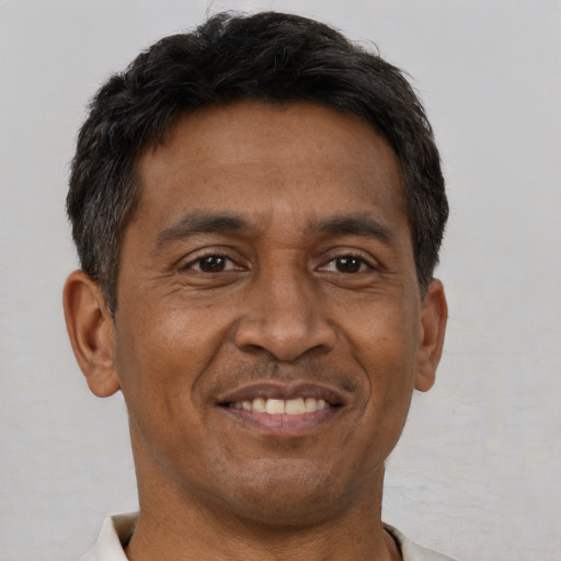 Joyful black adult male with short  brown hair and brown eyes