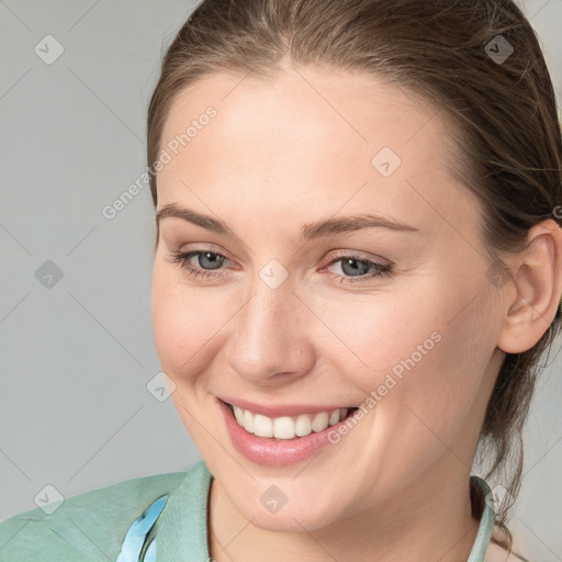 Joyful white young-adult female with medium  brown hair and grey eyes