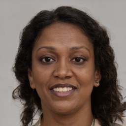 Joyful black adult female with long  brown hair and brown eyes