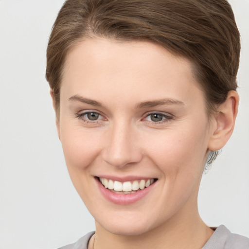 Joyful white young-adult female with short  brown hair and grey eyes