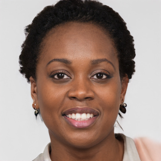Joyful black young-adult female with short  brown hair and brown eyes