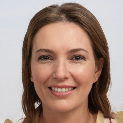 Joyful white young-adult female with medium  brown hair and grey eyes