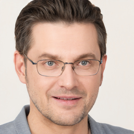 Joyful white adult male with short  brown hair and grey eyes