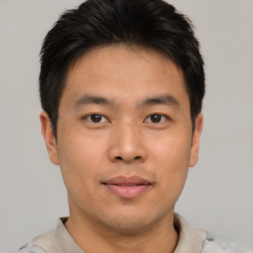Joyful asian young-adult male with short  brown hair and brown eyes
