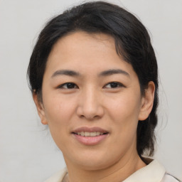 Joyful asian young-adult female with medium  brown hair and brown eyes