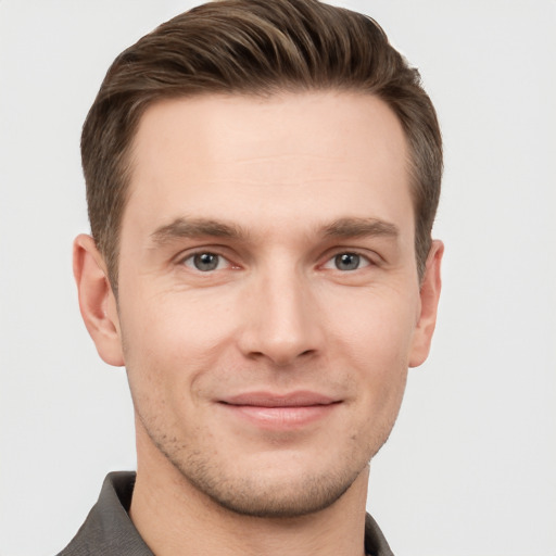 Joyful white young-adult male with short  brown hair and grey eyes