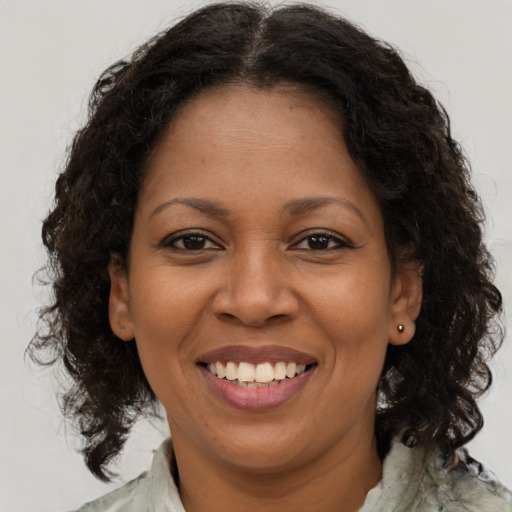Joyful black adult female with medium  brown hair and brown eyes
