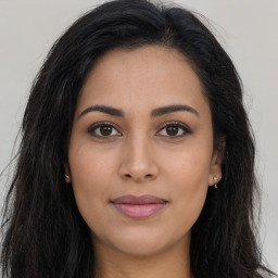 Joyful latino young-adult female with long  brown hair and brown eyes