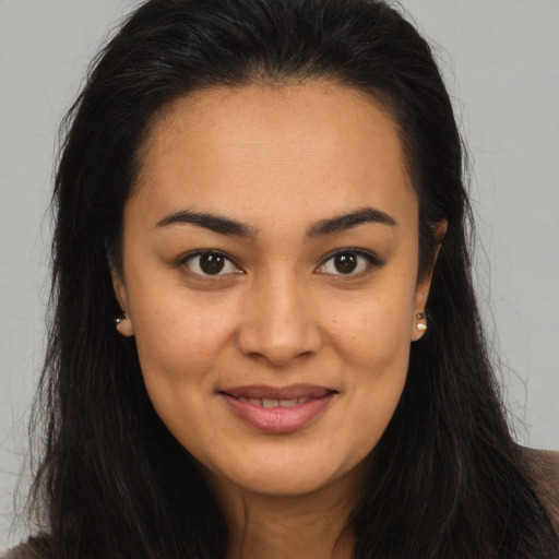 Joyful latino young-adult female with long  brown hair and brown eyes