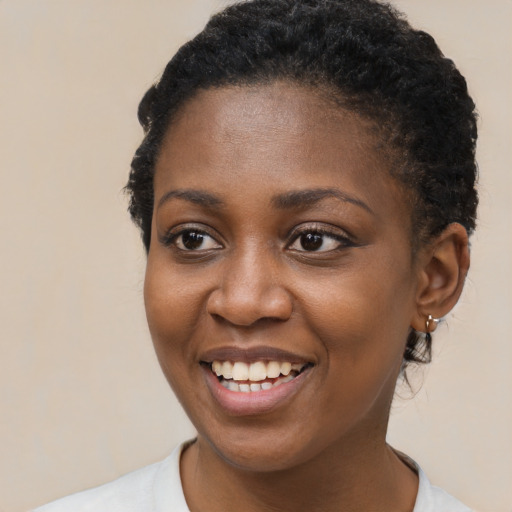 Joyful black young-adult female with short  brown hair and brown eyes