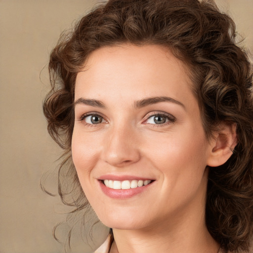 Joyful white young-adult female with medium  brown hair and green eyes