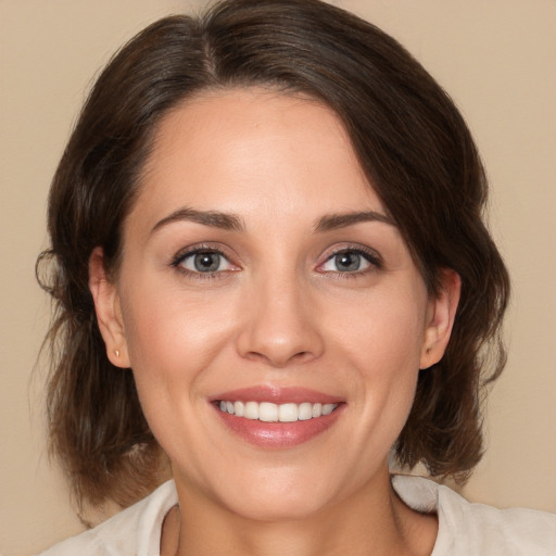 Joyful white adult female with medium  brown hair and brown eyes