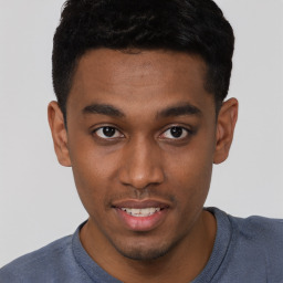 Joyful black young-adult male with short  brown hair and brown eyes