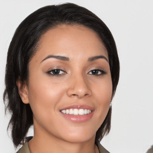 Joyful latino young-adult female with medium  brown hair and brown eyes