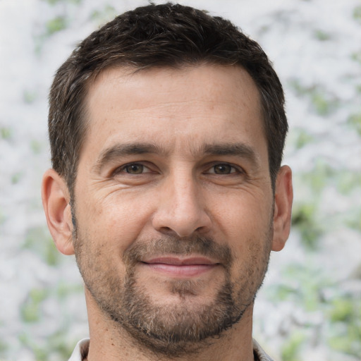 Joyful white adult male with short  brown hair and brown eyes