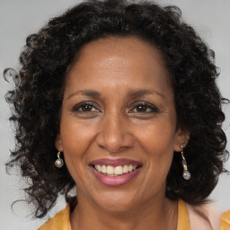 Joyful black adult female with long  brown hair and brown eyes