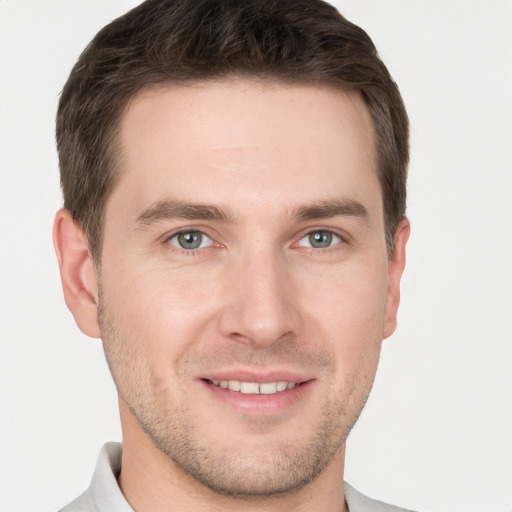 Joyful white young-adult male with short  brown hair and grey eyes