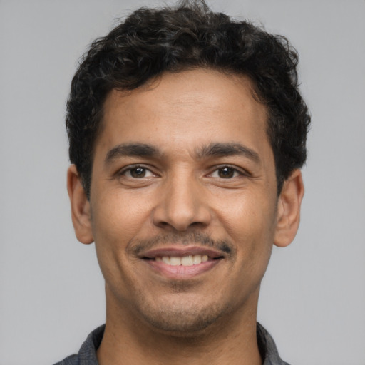 Joyful latino young-adult male with short  brown hair and brown eyes