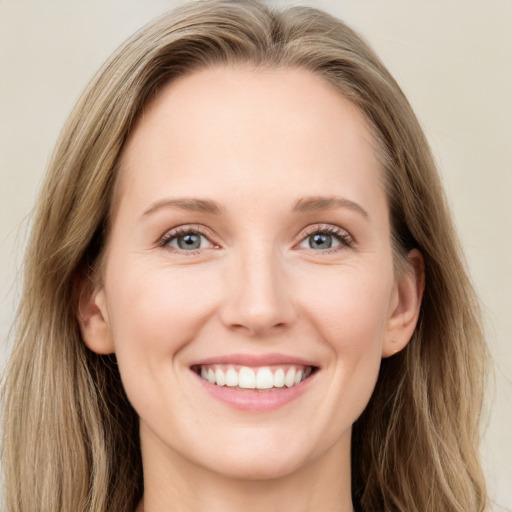 Joyful white young-adult female with long  brown hair and blue eyes