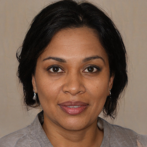 Joyful black adult female with medium  brown hair and brown eyes