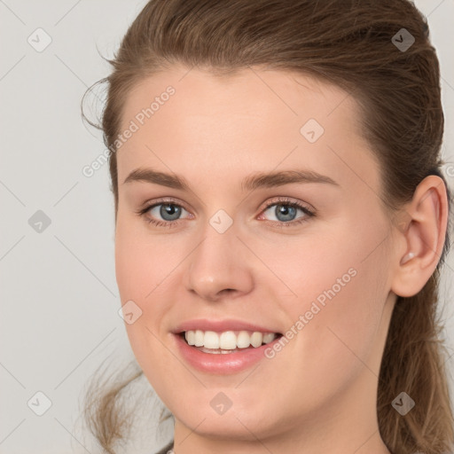 Joyful white young-adult female with medium  brown hair and grey eyes