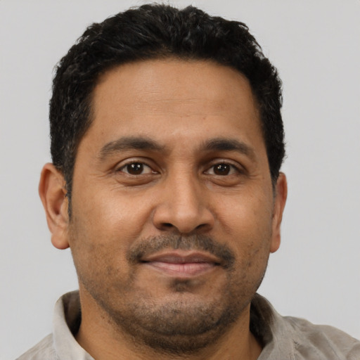 Joyful latino young-adult male with short  brown hair and brown eyes